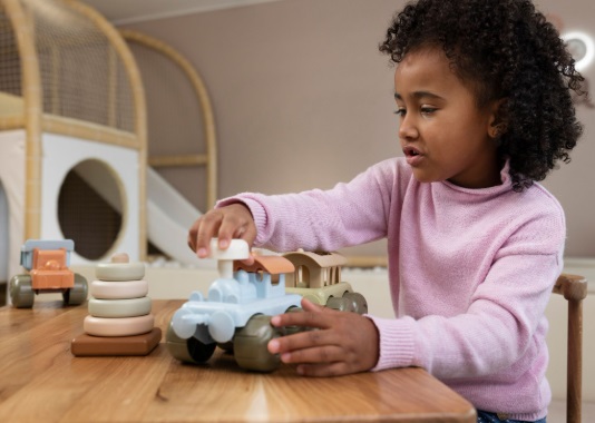 A black child playing with eco toys on a table.
