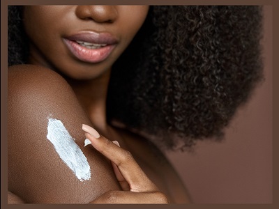 Black woman testing skin cream on the skin of her right arm