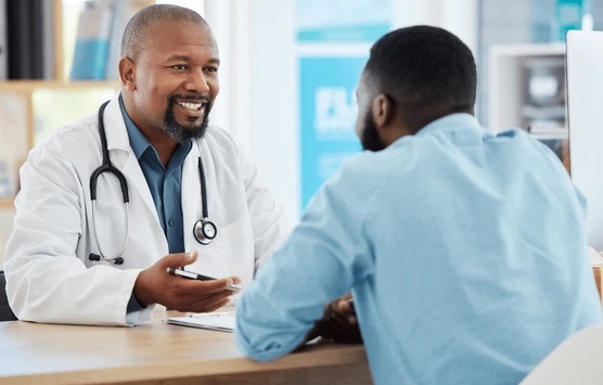 A doctor's office scene with black doctor taking a history from a male patient