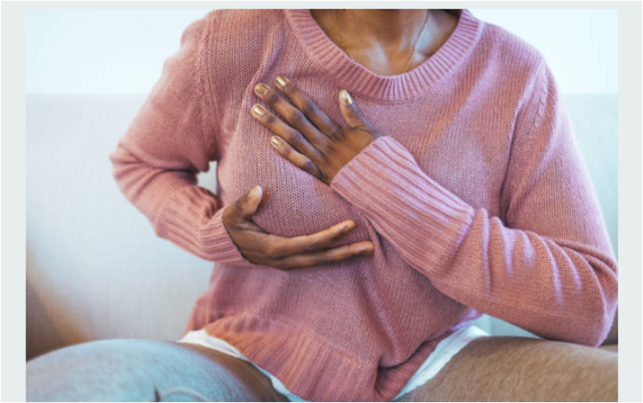 Black woman performing breast self examination