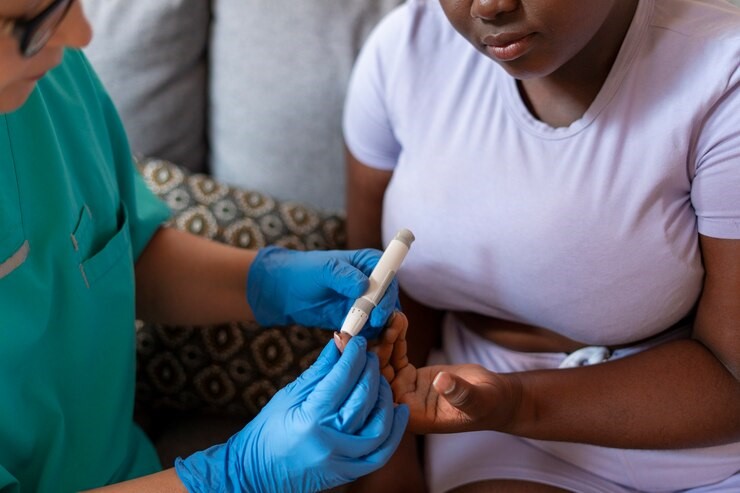 Close up of an African lady having a blood sugar check with a healthcare providder.