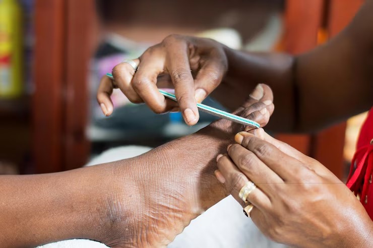 Close up of toenails being trimmed and filed by a manicurist