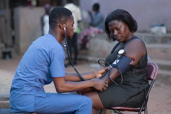 A humanitarian aid African doctor checking blood pressure in a female patient
