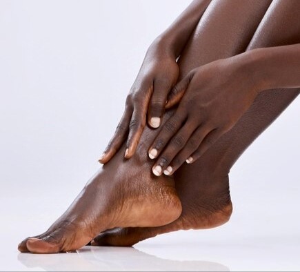Close up of the feet of an African woman being mositurised
