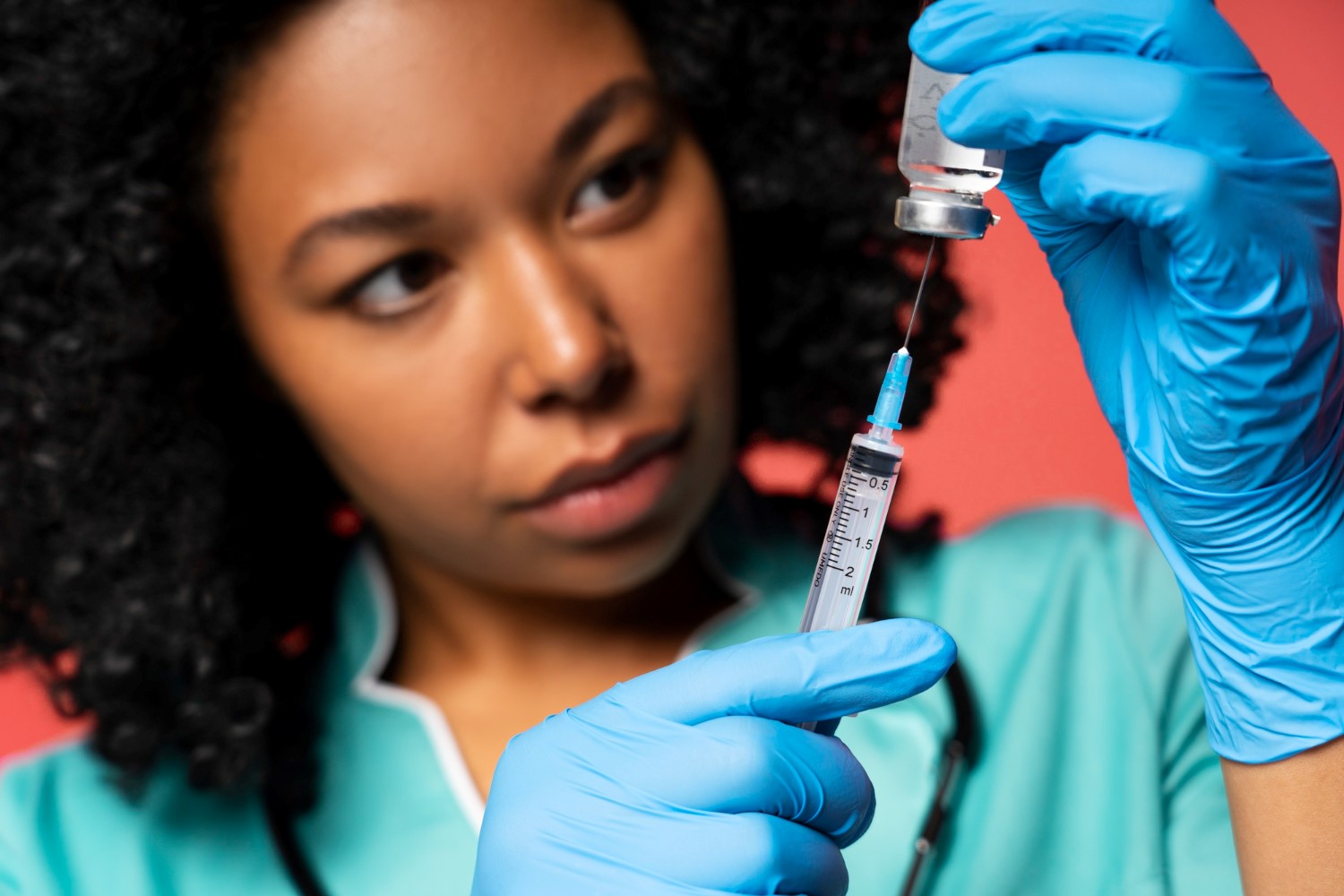 A nurse drawing HPV vaccine from a vial into a syringe for a vvaccination