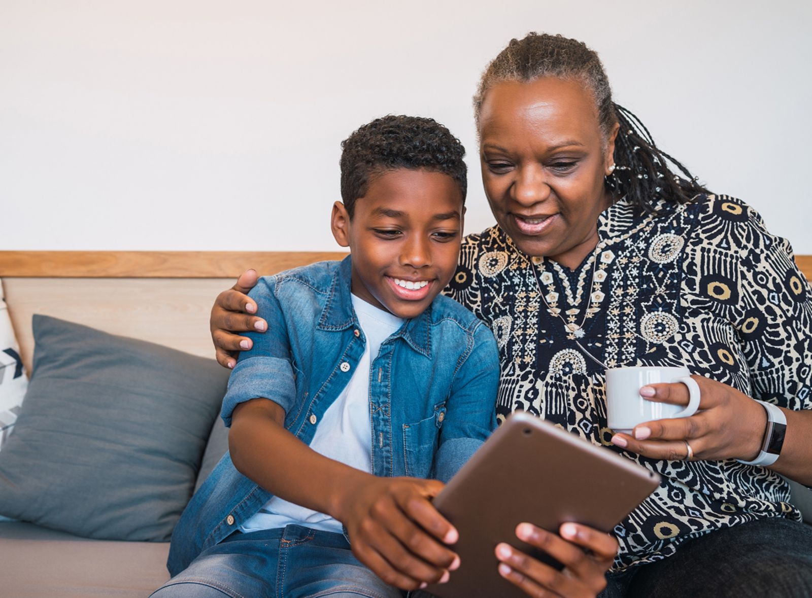 Portrait of a black migrant grandmother and grandson taking selfie witha digital tablet