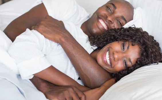 Black couple in warm embrace in bed