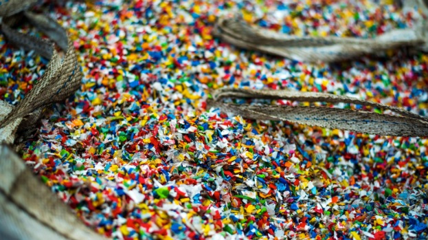 A sack of sorted multi-coloured shredded plastic garbage at a waste recycling factory.