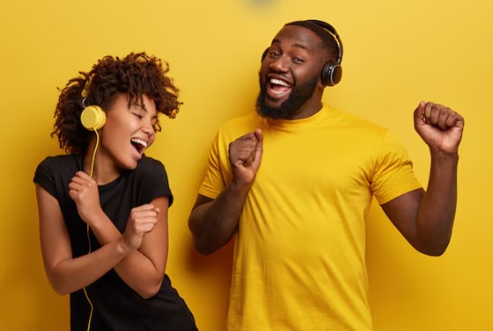 Young black couple jamming to music from headphones 
