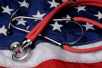 A red tubed stethoscope lies on a US flag