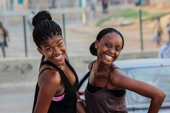 Two young smiling women standing together having fun