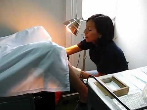 A female doctor performing a pelvic exam on a patient