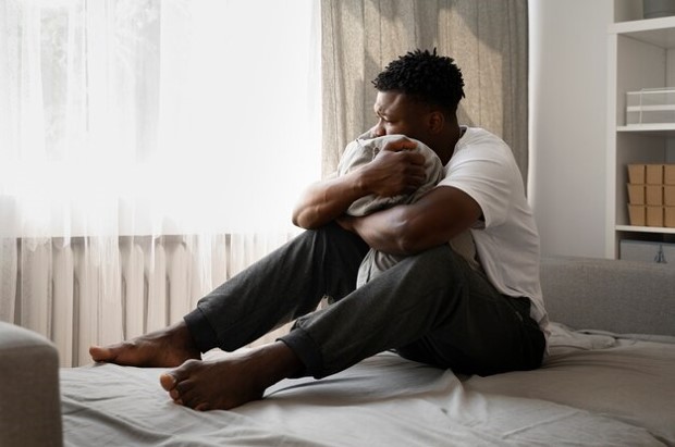 A young African male sitting alone and thinking
