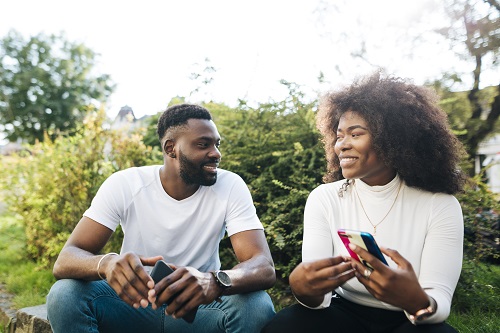 Black couple sitting at a beach talking