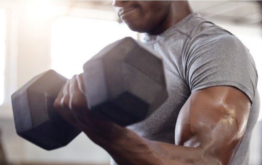 Patial image of a black man strength training with dunmbells