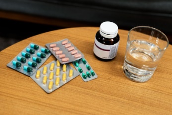 Oral diabetes and blood pressure medicines with a glass of water on a round table