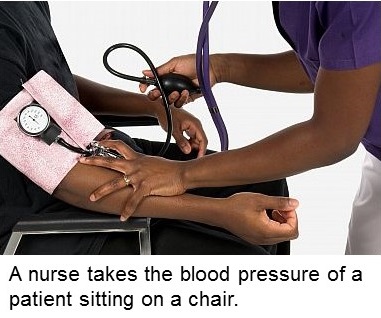 A nurse takes blood pressure of a patient sitting on a chair.