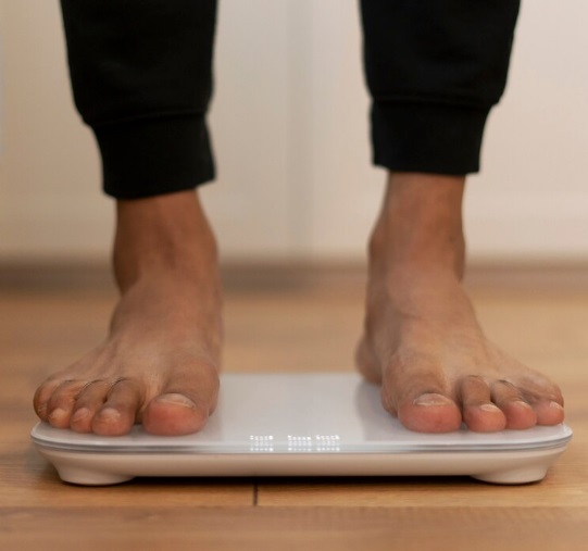 Close up of the feet of a black male on a weighing scale