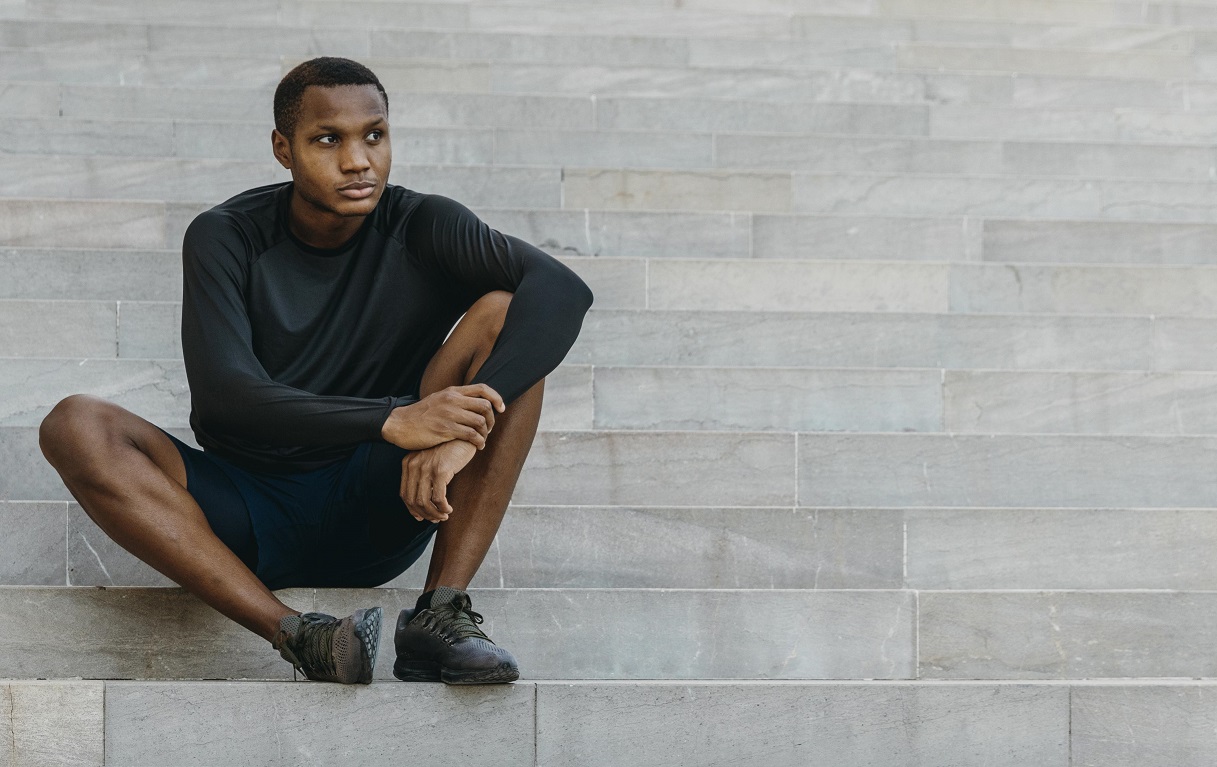 An African man sitting alone, looking contemplative
