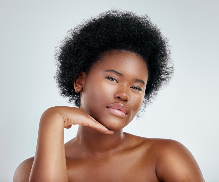 Portrait of a black young lady posing radiantly with glowing skin